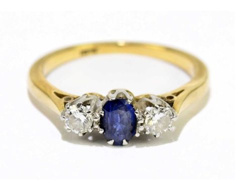 An 18ct yellow gold sapphire and diamond three stone ring with central oval sapphire flanked by twin round brilliant cut diam