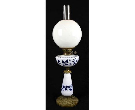 An Art Nouveau style oil lamp with clear glass bulbous shade and blue and white overlaid reservoir with tapering column, with