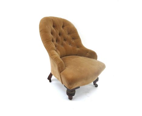 A Victorian button down upholstered nursing chair, on turned legs and castors.