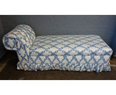 An Ottoman with button down scroll end and hinged compartment seat, upholstered in ivy patterned material, 157cm wide.