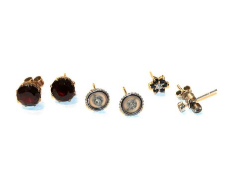 A pair of garnet solitaire earrings, stamped '9CT'; a pair of diamond solitaire earrings, unmarked; a pair of rock crystal, d