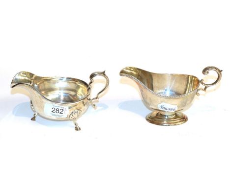 Two George V silver sauceboats, one by Adie Brothers, Birmingham, 1934, boat-shaped and on three scroll-capped feet, with bea