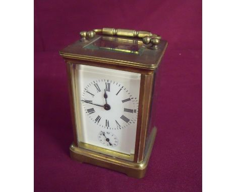 French brass and bevelled edge glass cased carriage clock with swing handle, white enamel dial with secondary dial and striki