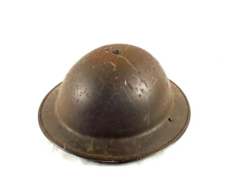 A tin helmet with nine volumes of 'The Great War'