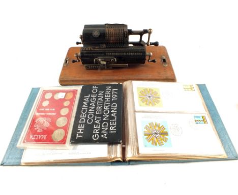 An album of first day covers, two coin sets and a German counting machine