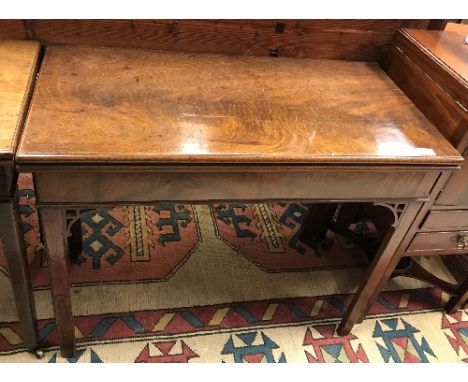A late George III mahogany rectangular fold over card table, the top with moulded edge above a plain frieze raised on square 
