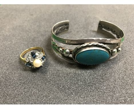 A yellow metal stone and pearl set dress ring together with a silver bangle with turquoise stone stamped "Sterling" to back