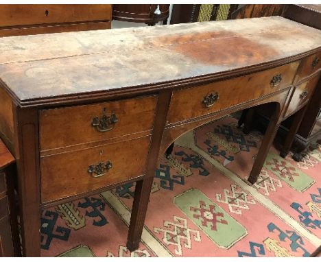 An early George III mahogany shallow bow fronted sideboard of slim proportions the central drawer flanked by deep cellarete d