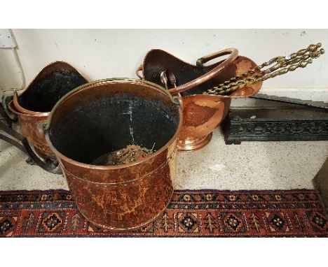 Two copper coal helmets and a copper log bucket together with three brass fire tools and a pair of copper coal tongs