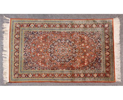  A Part-Silk Qum Carpet Persia, deep blue field, red, ivory and blue floral medallion, spanderels with same hue, flowering vi