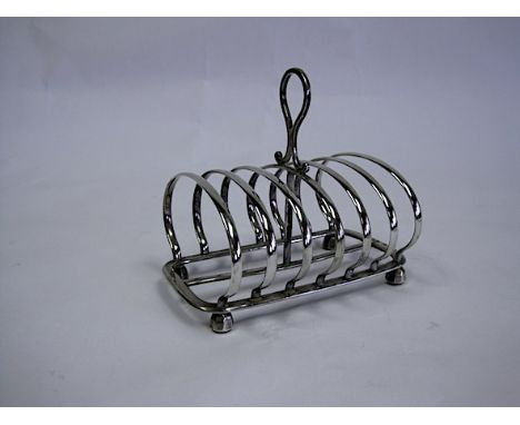  A Victorian Silver Toast Rack, Henry Wilkinson & Co, London, 1894 the rectangular frame centred with a carrying handle, rais