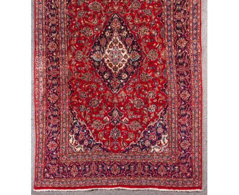  A Kashan Carpet Central Iran, red field, shabba's design, central deep blue medallion, leaf frond and flower motifs, wide bo