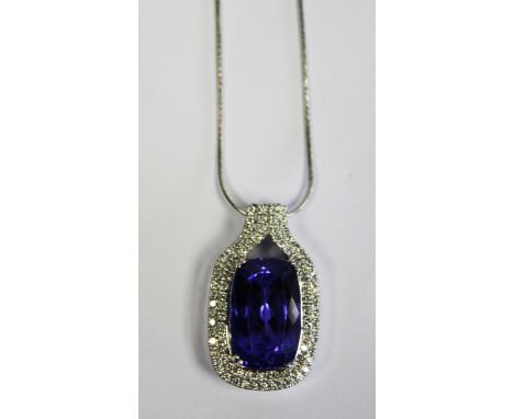  A Tanzanite And Diamond Pendant centred with a cushion- cut tanzanite weighing 17.540ct surrounded by three rows of round br