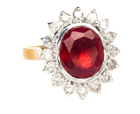  A Ruby And Diamond Cluster Ring centred with an oval ruby weighing approximately 4.15ct, enclosed within a conforming surrou