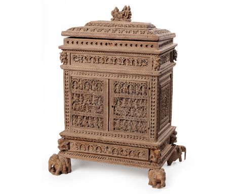  An Early 20th Century Indian Sandalwood Small Trinket Cabinet Deep carved hinged top having mythical figured finial, interio