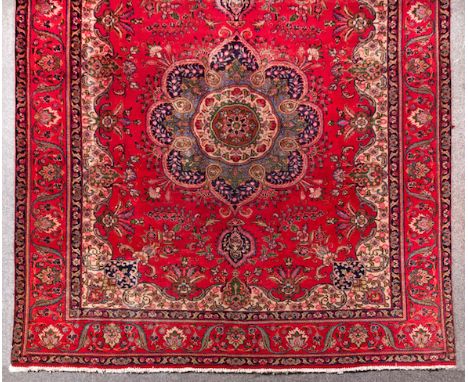  A Tabriz Carpet North West Iran, red field, central medallion with outswept lotus-form flowers, inner panel decorated with s