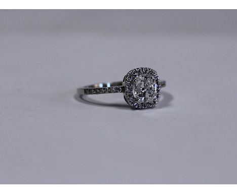  A Diamond Ring claw-set with a cushion modified brilliant-cut diamond surrounded by a conforming band of micropave-set diamo