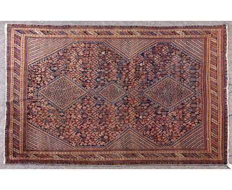  An Ushak Carpet West Turkey, brown field, central brown and blue diamond shaped lozenges, having arabesque design throughout