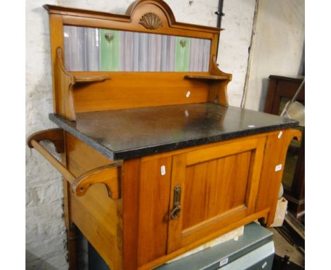 An Art Nouveau satin walnut wash stand with raised tile and marble top and single door.
