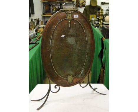 An oval copper and brass firescreen.