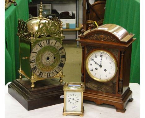 A brass carriage clock, carved mahogany 2-train mantel clock and a brass lantern clock.