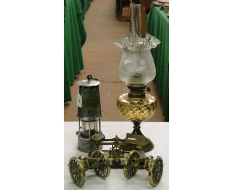 A miner's lamp by the Protector Lamp & Lighting Co., a pair of table cannon, postal scales and an oil lamp.