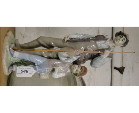 A Lladro group with a small boy holding a fish.