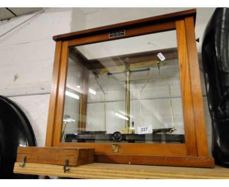 A brass balance scale in glazed case with a mahogany cased set of weights.