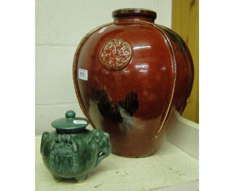 An Oriental red glazed jar with embossed and painted decoration and a small pot with elephant design.