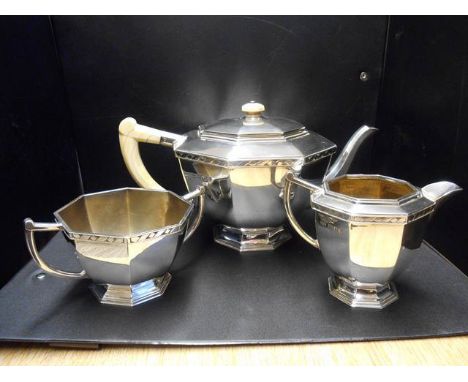 A mid 20th century three piece silver tea service, London 1935/37, maker Robert Edgar Stone, of octagonal form with zig-zag b