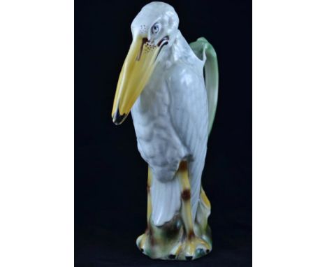 A continental Majolica pelican jug with green handle, marked to base 'R' - H35cm CONDITION REPORT: Hairline crack to base