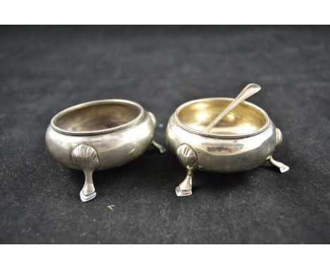 A cased pair of Victorian circular silver salts with hoof feet, one spoon, London 1885, maker William Hutton - approx total w