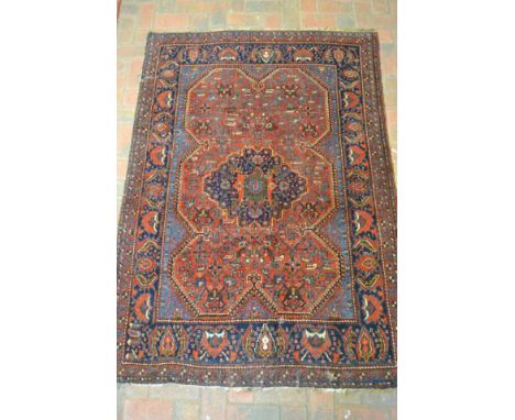 A Middle Eastern rug with centre medallion, predominantly in blue and red - approx 175x123cm CONDITION REPORT: moth damage an