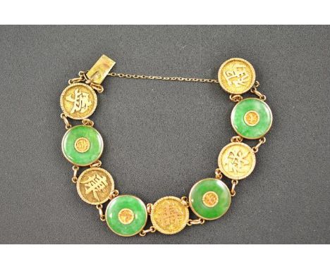 A Chinese yellow metal and jade bracelet with eight discs, stamped 18 - approximate gross weight 18.3g. CONDITION REPORT: Goo