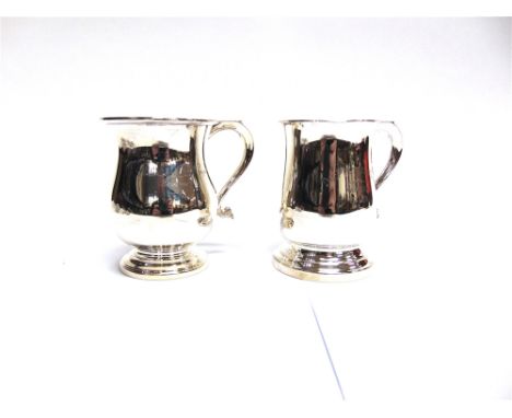 A SILVER MUG maker J.M., Birmingham 1960, of baluster shape with S scroll handle, inscribed, 10cm high; with another similar 