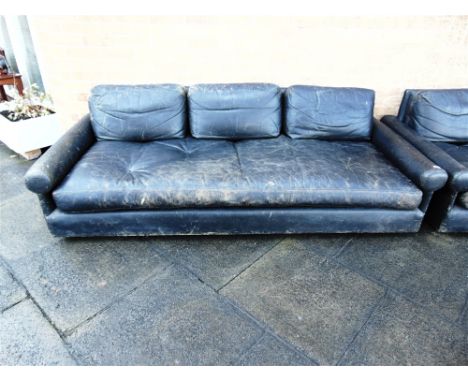 A LARGE BLACK LEATHER SOFA  of low and deep shape, three cushions to the back, the seat upholstered in a single piece of leat