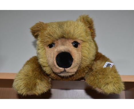 A STEIFF URS BROWN BEAR, No.069673, soft plush brown bear in a lying position, button and tag to left ear, very good conditio