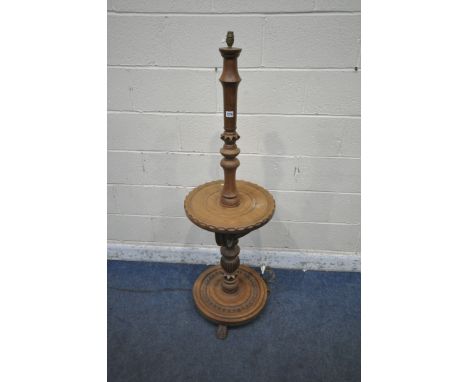 A LATE 20TH CENTURY OAK STANDARD LAMP, with geometric carvings, a circular shelf and base, raised on shaped feet, approximate