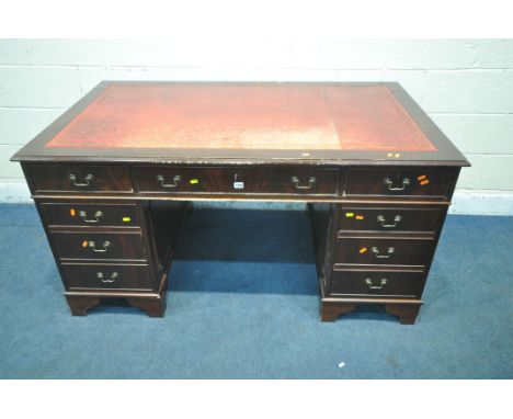 A 20TH CENTURY MAHOGANY TWIN PEDESTAL DESK, with red leather writing surface, fitted with eight assorted drawers, on bracket 