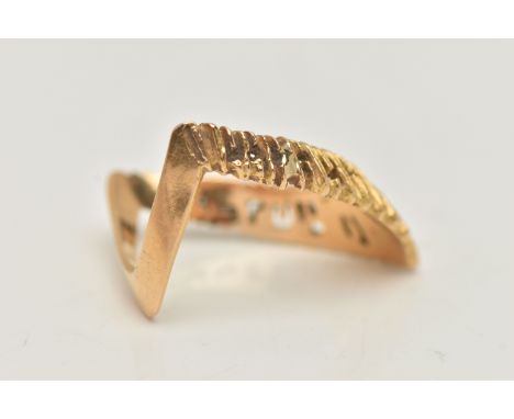 A YELLOW METAL TEXTURED WISH BONE RING, textured V shape, and polished reverse, stamped 750, ring size centre O 1/2, approxim