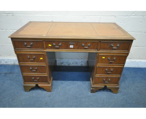 A 20TH CENTURY YEW WOOD TWIN PEDESTAL DESK, with leather writing surface, fitted with nine assorted drawers, raised on bracke