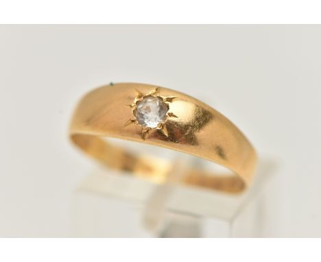 A YELLOW METAL SINGLE STONE RING, star set with a colourless circular cut sapphire, to a polished band, unmarked, ring size R
