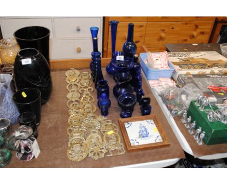 A quantity of various horse brasses, blue table glassware and a framed tile 