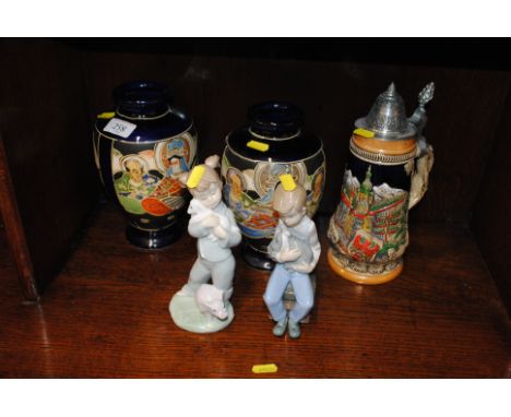 A pair of Japanese decorated vases, a German tankard, and two Nao figures 