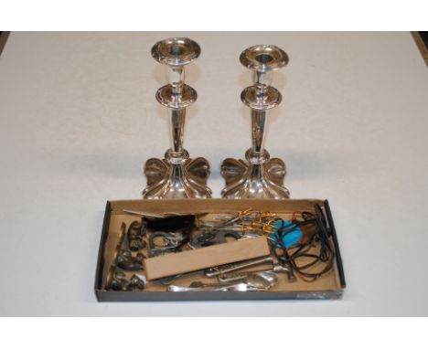 A pair of silver plated candlesticks and a box containing enamel decorated spoon and fork, other cutlery, padlocks etc.