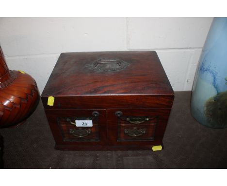 A Victorian walnut trinket / sewing cabinet with lifting top compartment and drawers enclosed by glazed doors 