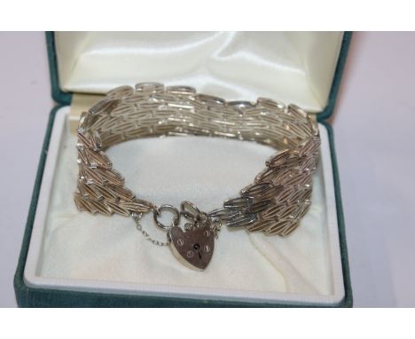 A wide solid Sterling silver Hallmarked bracelet with heart lock, approx. 57.5gms