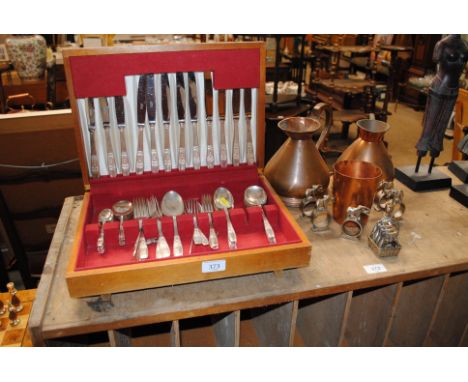 A canteen of silver plated cutlery and two copper measures, napkin rings etc.