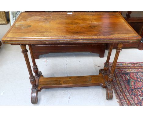 An early 19th century rosewood rectangular fold-over baize lined card table on turned fluted legs, plain stretcher and scroll