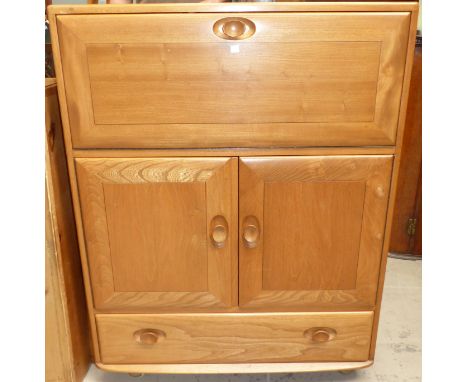 A modern Ercol light elm drinks cabinet with fall front, double cupboard and drawers